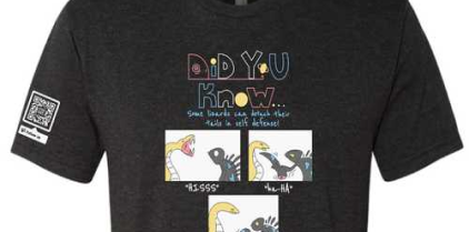 Black t-shirt with a graphic of a comic strip containing lizard characters.